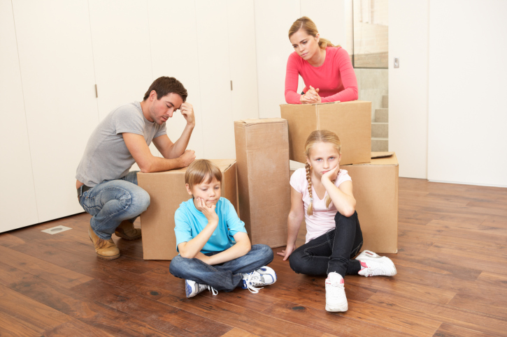 Young family looking upset among boxes